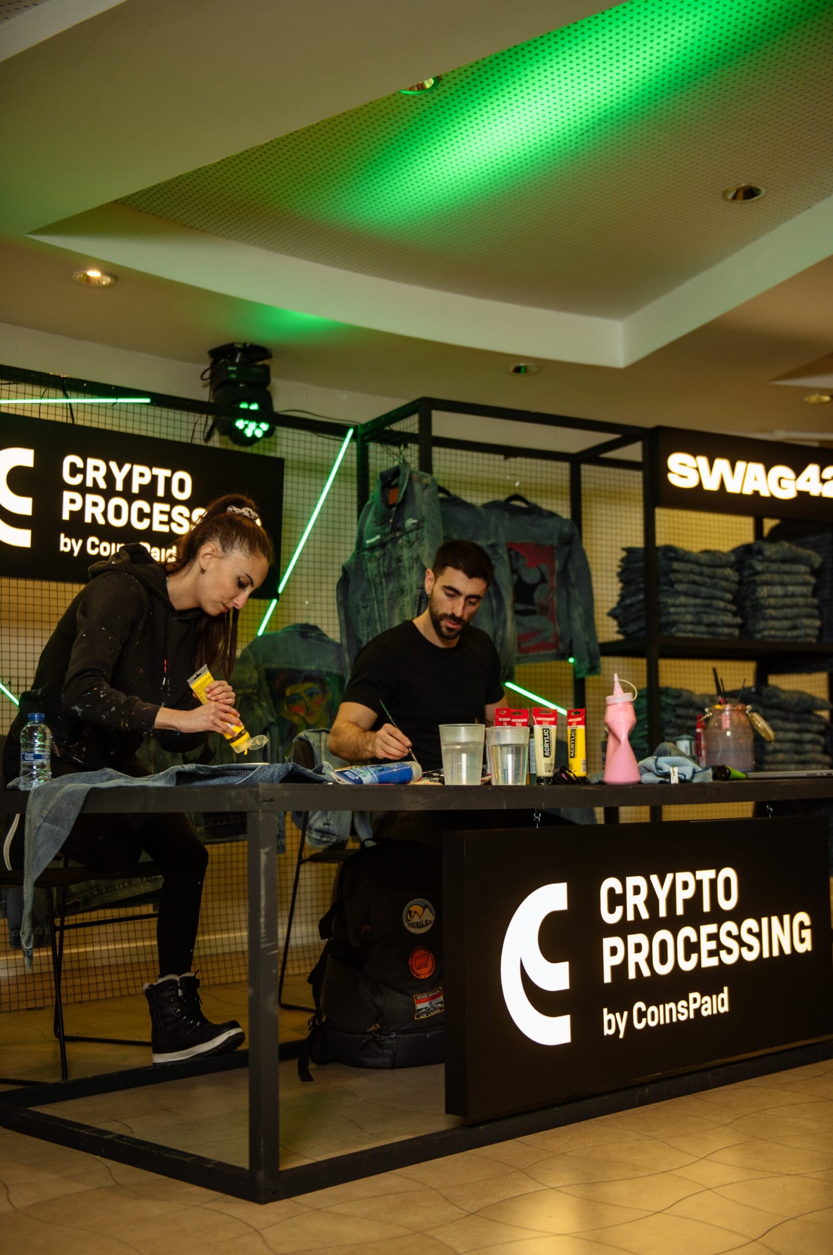 Artists painting event merch in front of the public