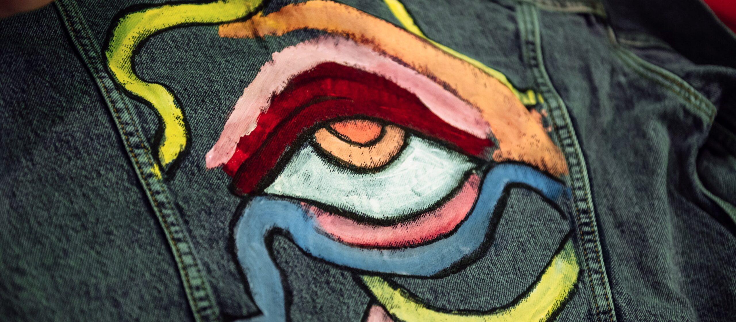 A jeans jacket is being painted in the real time at the event.