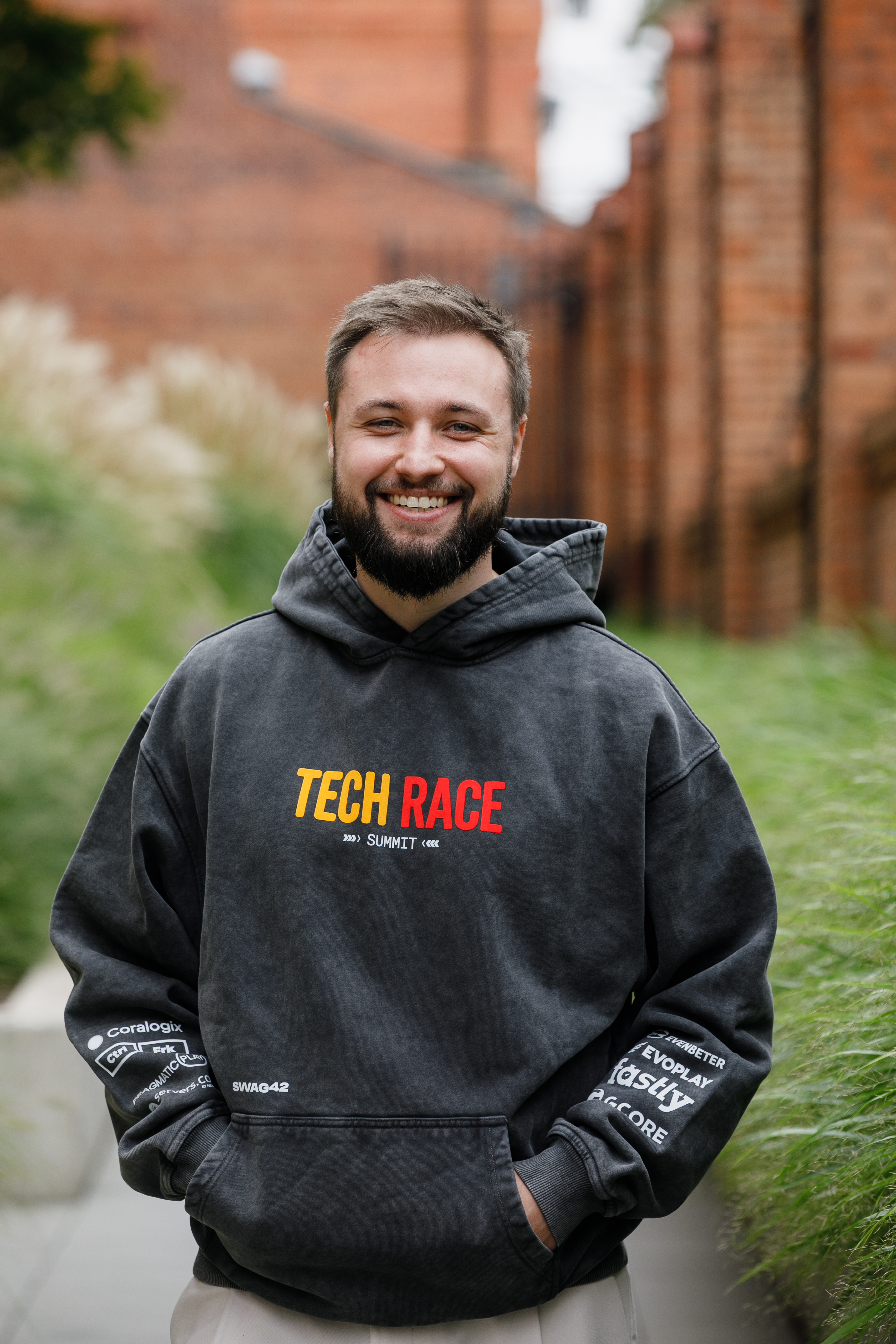 Front view of the grey Tech Race Summit hoodie with event branding and partner logos on the sleeves